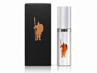 LaCroy IMPI Original men's pheromone cologne in a silver spray bottle with copper warrior emblem, displayed beside its black retail box against a white studio background.