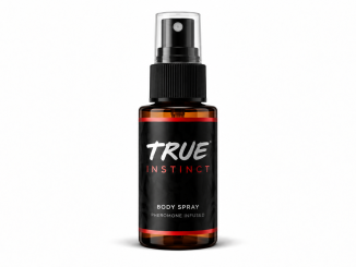 TRUE Instinct men's pheromone body spray in an amber bottle with a black label, white TRUE logo, red INSTINCT lettering, and transparent spray cap against a white background.